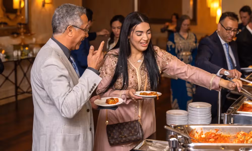 Guests getting food during cocktail hour at wedding.