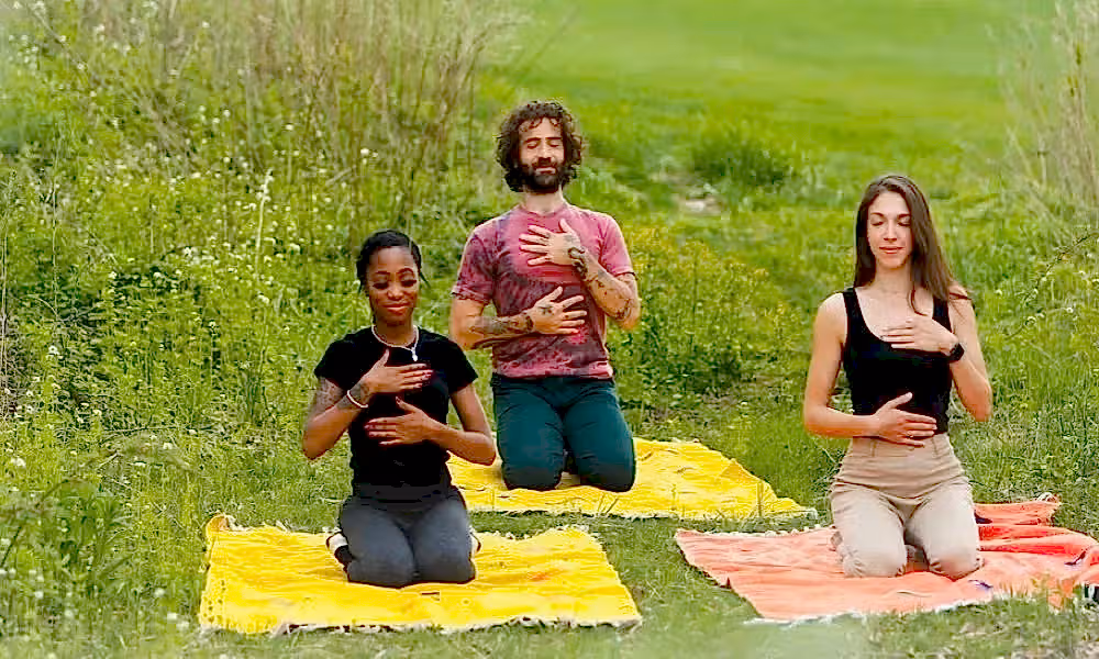 Group of three people meditating in a field  in New Jersey. 