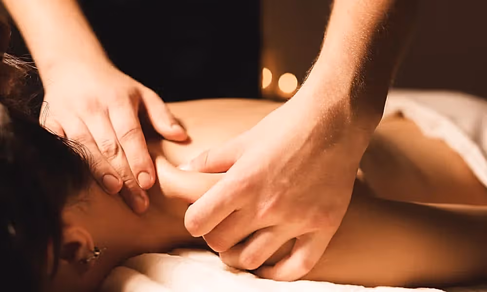 Hands pinching shoulder giving massage.