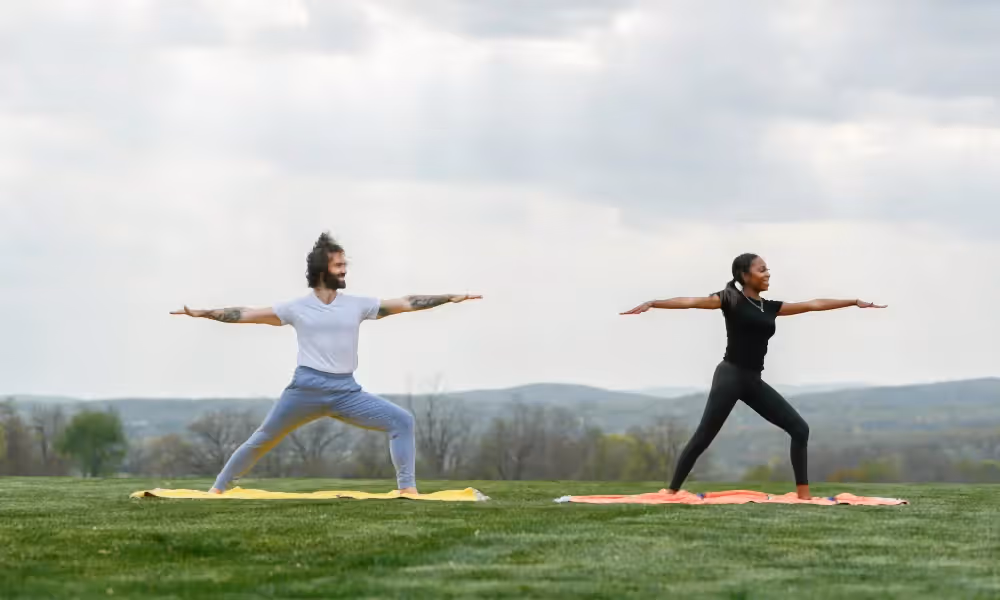 Couple doing warrior yoga pose