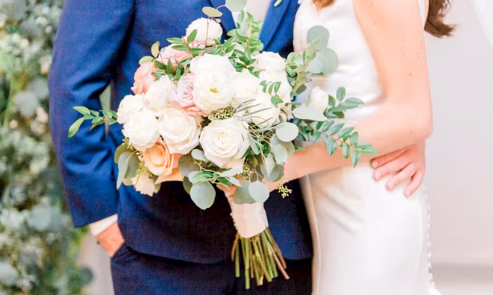 Bride and groom holding flower bouquet