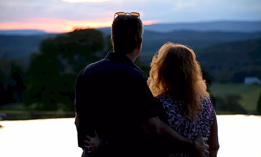 Couple looking at the sunset at vista 180 pool.