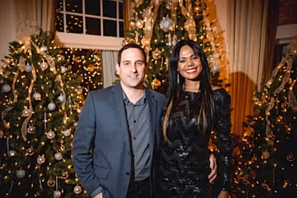 Couple in front of Christmas tree decorations
