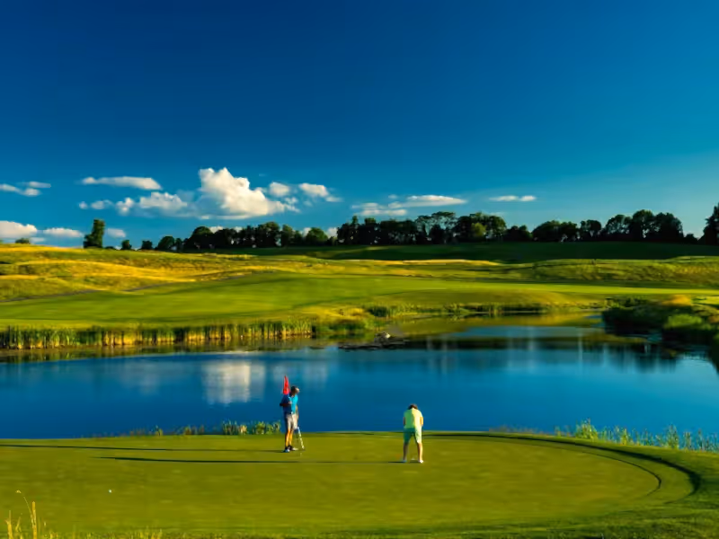 Two guys on the putting green of a golf course at Crystal Springs Resort